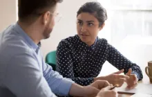 Two teachers talking at table.