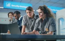 TSA workers at a laptop