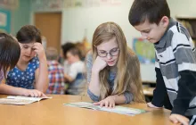 Elementary kids working together with workbooks