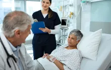 Provider and older patient in hospital bed
