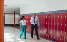 Principal and teacher in school hallway