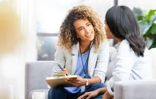 Woman with clipboard talking to colleague