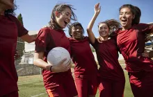 Happy young women playing soccer