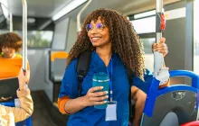 Young woman in scrubs commuting by subway
