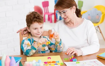 Teacher working with student at his desk
