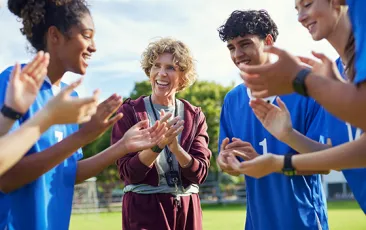 Coach celebrating outside with players