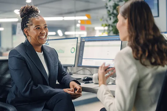 Female colleagues chatting at desk