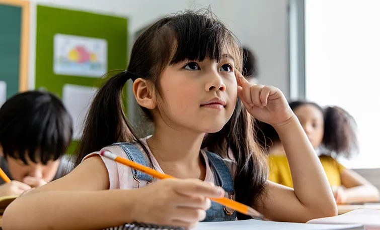 Elementary student with notebook in classroom
