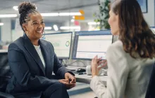 Female colleagues chatting at desk