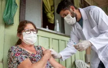 doctor giving shot to woman in rural setting